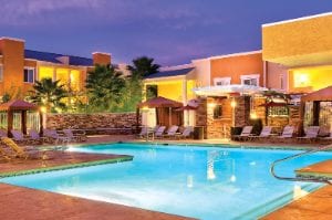 The outdoor pool of WorldMark Tropicana surrounded by sun loungers and cabanas.